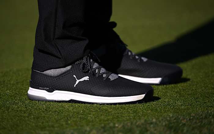 View of Rickie Fowler's black and white PUMA golf shoes.